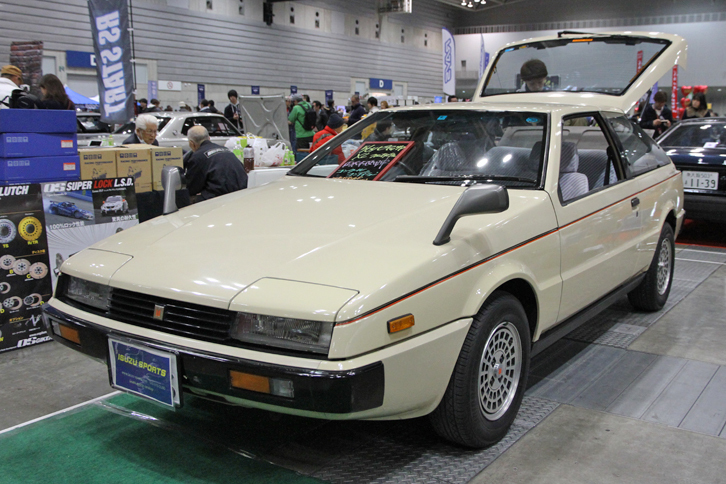 ISUZU SPORTSが出展していた1981年「いすゞ・ピアッツァXL」。ドアミラーが認可される前で、デザインを手がけたジウジアーロが激怒したという説もあるフェンダーミラー付きの初期型。特徴的な純正アルミホイール付きのフルオリジナルで、雨天未使用という極上車。