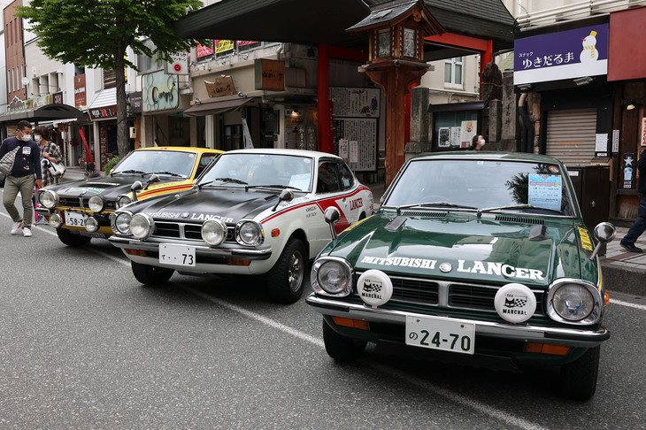 ラリー仕様に仕立てられた、型式名A73こと初代「三菱ランサー1600GSR」。年式は手前から2台が1974年、奥が1975年。道の反対側にも2台のラリー仕様A73が並べられていた。