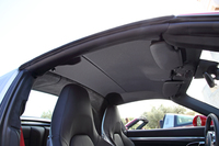 トップを車内側から見たところ。ルーフライニングはトップ部がブラックのファブリック、“タルガバー”部が同じくブラックのアルカンターラとなる。
    