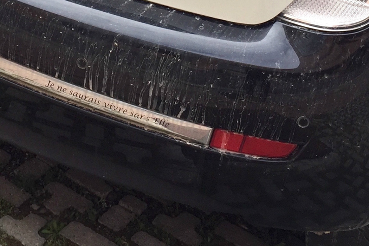 街角で見かけた「ランチア・イプシロン ELLE仕様」のリアパンパー。「彼女なしには生きられない」の文字がフランス語でつづられている。
