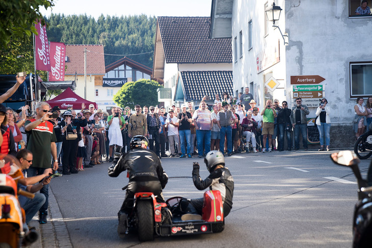 ライダーたちを待ち受ける観客。みな目を輝かせながらレーシングマシンを待ち、手を振る。