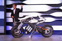 ロボットバイクの「モトロイド」は、柳社長に「Stand up!」と声をかけられると、自らバランスを取りながら器用に自立。歩む社長について走るデモを披露した。