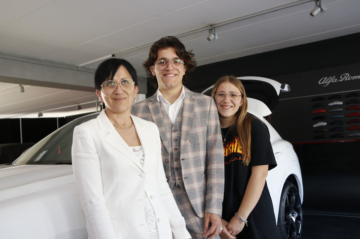 金融コンサルタントのマリエッラさん（写真左）と家族。実車を見たあとの感想は？　と聞くと、「優雅さとスポーティネスを兼ね備えたアルファ・ロメオらしさを十分に感じました」と答えてくれた。