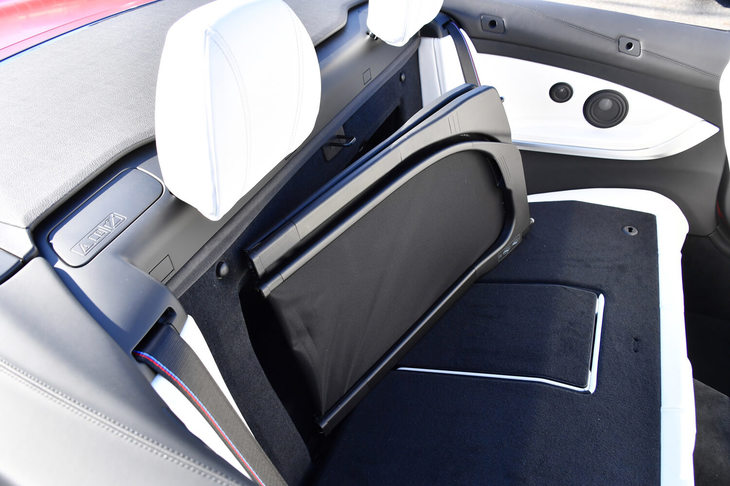 後席の背もたれの裏には、折りたたみ式のウインドディフレクターがおさまる。これを除くことでトランクルームとキャビン後部をつなげば、長尺物を積むこともできる。