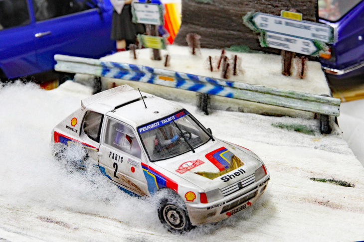 1985年のモンテカルロラリーで、雪のチュリニ峠を疾走する「プジョー205ターボ16」。タミヤ製1/24キットを使ったジオラマだが、流し撮り写真のように背景をボカしてスピード感を表現している。このアイデアには拍手！