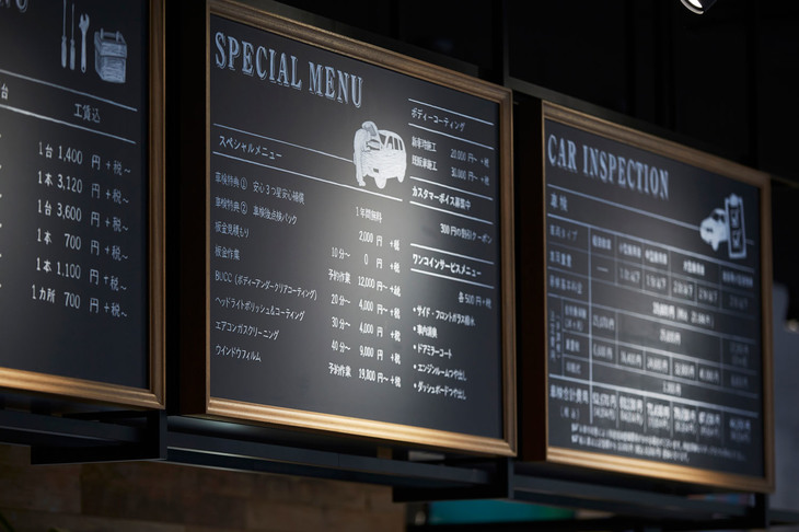 1階はウッド張りで、まるでサードウエーブコーヒー店？ という雰囲気の商談スペース（ここでコーヒーだけ飲んでいる人もいる）。黒板風に書かれたメンテナンスメニューも一般客にとって敷居を低くしてくれている。