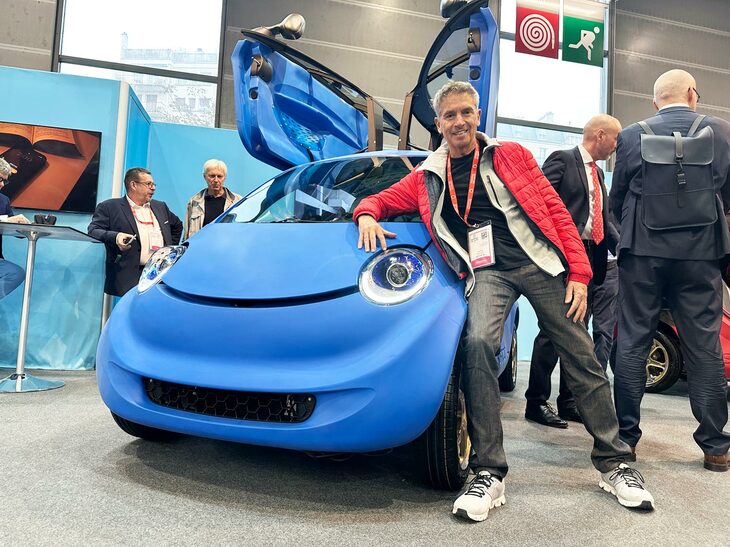 パリモーターショー会場で。「ソフトカー」はスイスの電動マイクロモビリティー研究開発会社による参考出品車だ。一般的な乗用車で約4万5000点ある部品点数を1800点にまで減らしている。現在、生産ライセンスの供与先を募集中だ。デザインを担当したフランソワ・ビュロン氏と。