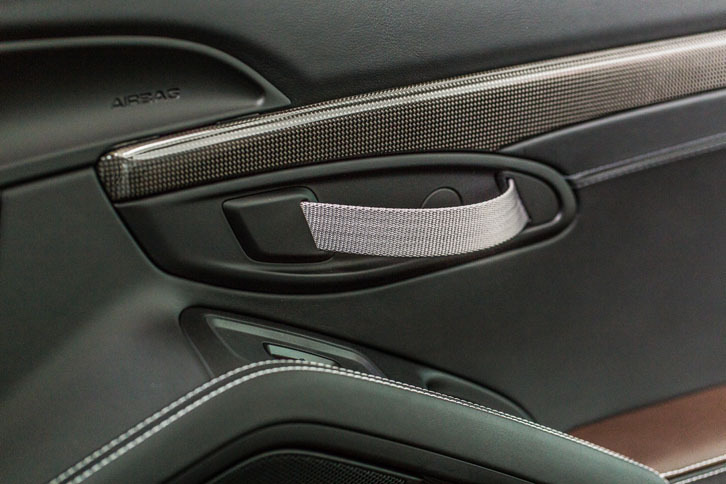 車内側のドアノブは、ストラップ状になっている。カーボンのパネル類も特徴的なディテールだ。