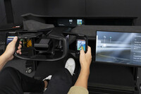 左右グリップの外側に置かれた液晶パネルは、いわばステアリングスイッチの進化形。聞けば、従来の「円形ステアリングのスポーク部に並んだスイッチ類」については、年配の方などから「使いにくい」という評価もあるという。手元の液晶パネルは、操作に際して凝視する必要はなく、ドライバーは連動する（前方に見える）ヘッドアップディスプレイを眺めつつ、手元のパネルをタッチ＆スライドする。