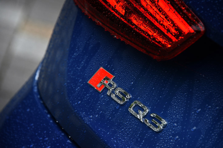 テールゲートに装着された「RS Q3」のバッジ。赤いひし形のマークは「アウディスポーツ」の象徴で、アウディスポーツ店のデザインにもそのモチーフが使われている。