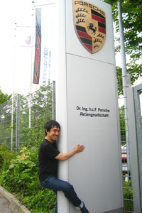 ポルシェ本社にて、その看板に限りない憧憬の念をぶつけるマリオ二等兵。