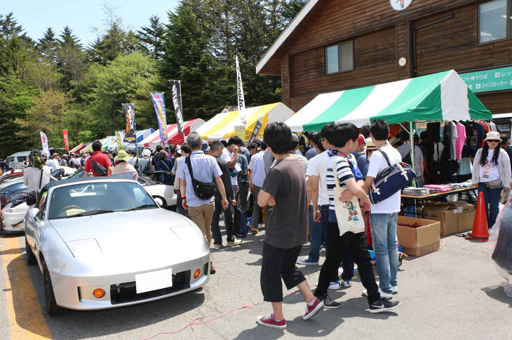 名物のひとつ、ショッピングストリートには、全国各地の「ロードスター」専門店やアフターパーツメーカーなどが出展。イベント特価の掘り出し物も少なくなく、多くのファンで賑（にぎ）わう。大きなパーツを抱えながら、愛車へと向かう笑顔の参加者の姿もちらほら……。よほどお得な買い物ができたに違いない。