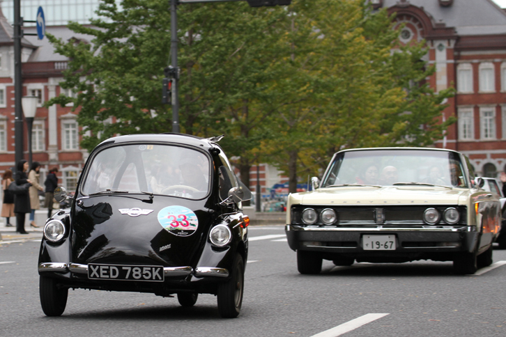 ドイツのハインケルを英国でライセンス生産した1963年「トロージャン200」と、フルサイズのアメリカ車である1967年「クライスラー・ニューポート コンバーチブル」。出走車両中、最小クラスの一台と最大の一台が仲よくランデブー。