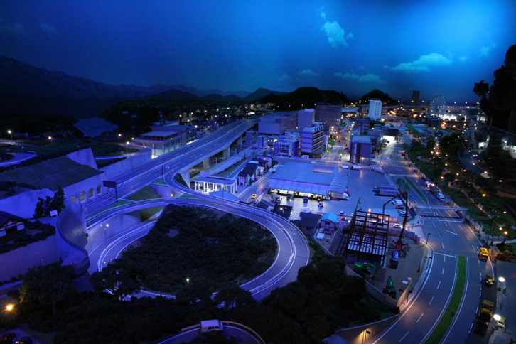 いすゞプラザの巨大ジオラマは、15分で1日の動きを表現。しらじらと夜が明けるところから始まる。