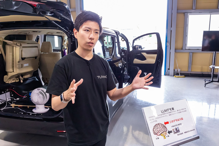 「アルファード」に搭載する自動運転システムを山本CEOが説明。「チューリングでは大規模言語モデル（LLM）を活用して車両の制御を行います。これまでのADASを反射神経的、小脳的なシステムとすれば、自分で認識・推論・判断ができるこちらは、人間で言えば大脳にあたるシステムです」と述べた。
