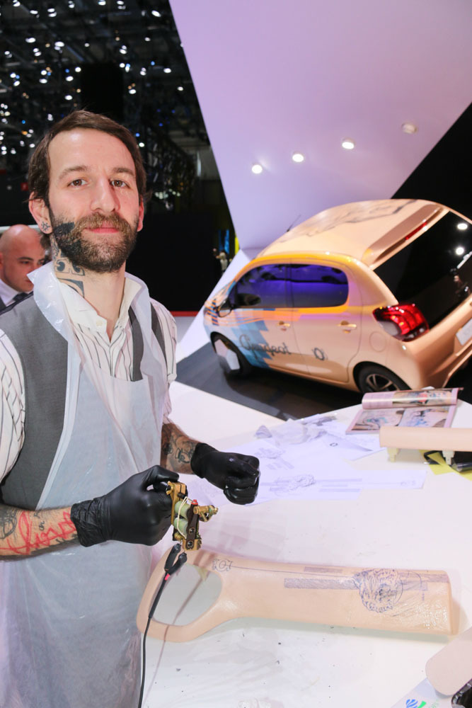 2014年ジュネーブショーで、プジョーはタトゥーアーティストのXOIL氏をフィーチャー。後方の「108」のグラフィックを担当したほか、ダッシュボードのペインティングを実演した。