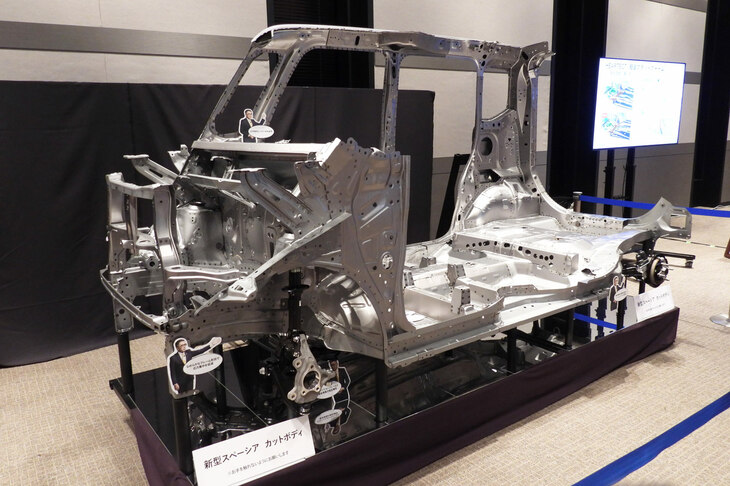 「軽くて安全な車体」の解説エリアに展示された、現行「スペーシア」のカットボディー。スズキでは車両の軽量化を統括する技術本部長のもと、各開発部門が協力。総力を挙げて重量軽減に取り組むという。