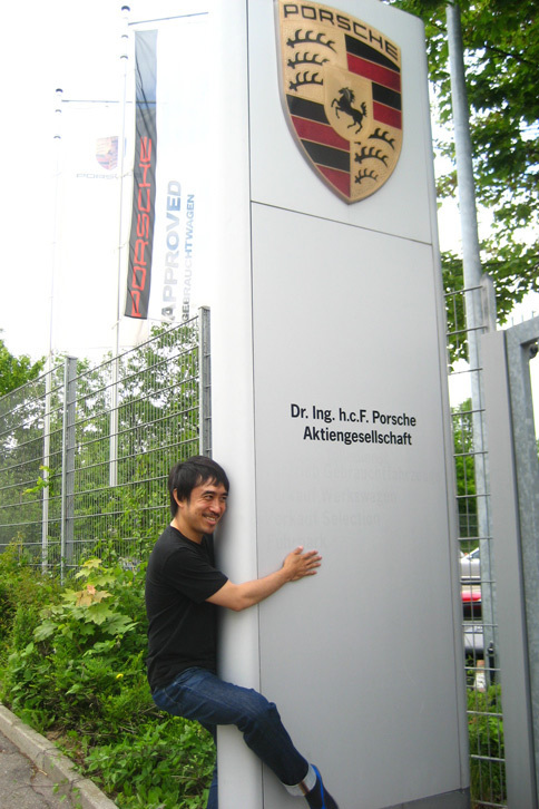 ポルシェ本社にて、その看板に限りない憧憬の念をぶつけるマリオ二等兵。