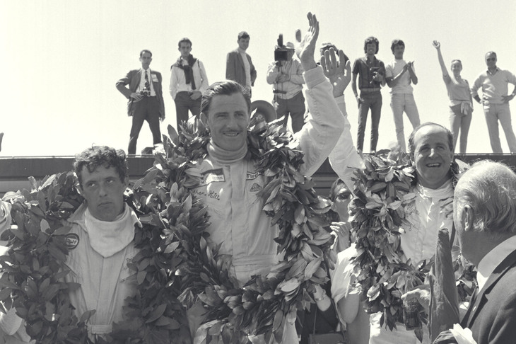 1968年の第2戦スペインGPにて、表彰台の中央に立つグラハム・ヒル。この年、ロータスはコンストラクターズタイトルを、ヒルはドライバーズタイトルを獲得した。