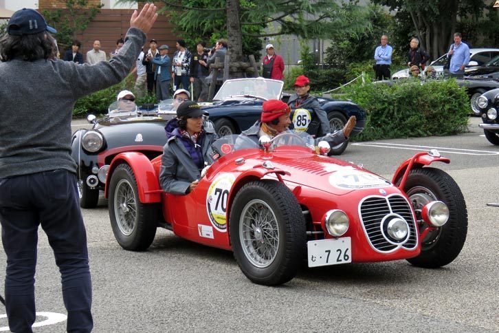 戦後のマセラティを代表するレーシングスポーツカーである、「マセラティA6 GCS」（1948年式）。ドライバーを務めるタレントの堺 正章氏が、観客に笑顔で手を振る。