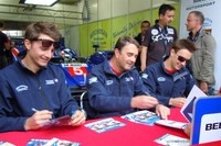 両隣の息子たちとともにサイン書きに追われるのは、元F1ドライバーのナイジェル・マンセル。