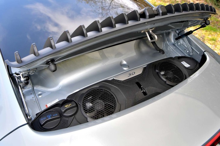 リアには最高出力385PSの水平対向6気筒エンジンがおさまるが、フードを開けて見えるのは冷却ファンとオイル・冷却水の投入口のみ。エンジン本体を眺めることはできない。