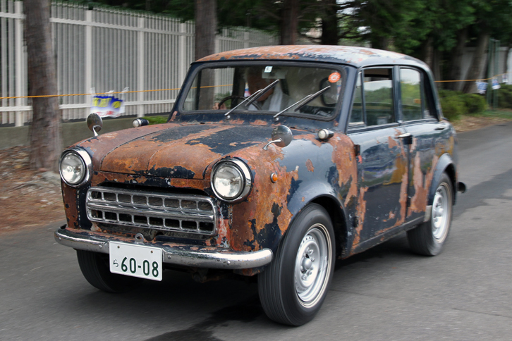 1954年「ダットサン113型」。ボディーは一部塗装がはがされてサビサビ、だがクロームパーツは外され保管されていたのか、キレイな状態という不思議なコンディション。