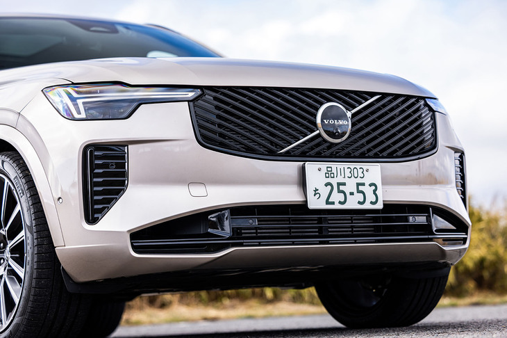 ボルボの新世代をけん引する電気自動車「EX90」（日本未導入）に通じるデザインが新たに採用された「XC90」のフロントフェイス。斜線を重ね合わせた意匠のグリルや、マトリックスデザインLEDを用いてスリムになったトールハンマーヘッドランプなどが目を引く。
