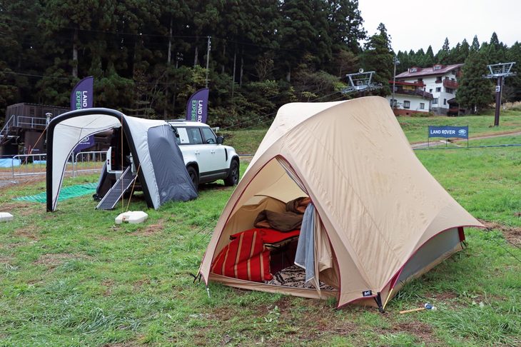 ゲレンデに展示された、MOSS TENT WORKSのテントと「ディフェンダー110」の用品装着車。愛車のディフェンダーとともにキャンプを楽しみたいと考えるオーナーもきっと多いのだろう。その姿も、実に絵になる。