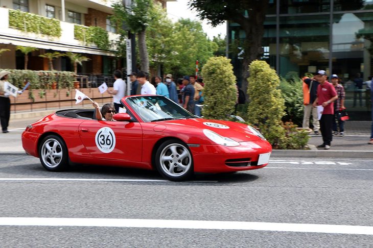 軽快なスタートを見せる「911カブリオレ」（996）。沿道からスタートを見守る観客たちにコドライバーが旗を振って応えていた。