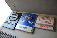 サービス工場の入り口に掲げられた看板。2013年1月に欧州での販売を終了したダイハツ車だが、その整備は継続されている。