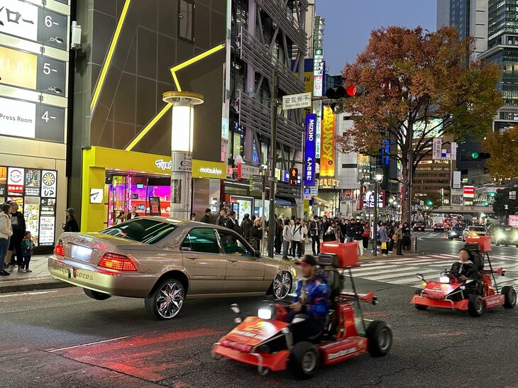渋谷109前の交差点で。ひと月前のニュースで話題となった事故車と同じく、ハイドロ機構をもったローライダーと、外国人観光客が運転するカート。