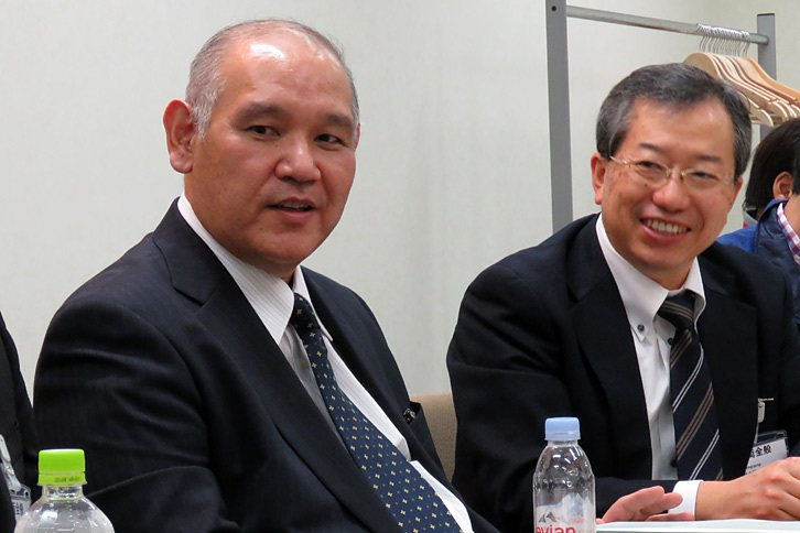 新型「コースター」の開発において、主査を務めた山川雅弘氏（左）と、笑顔で質疑に答える梁井康平氏（右）。エアサスペンションについては電圧の12Vへの一本化に伴い、ひとまず非設定とされたとのこと。