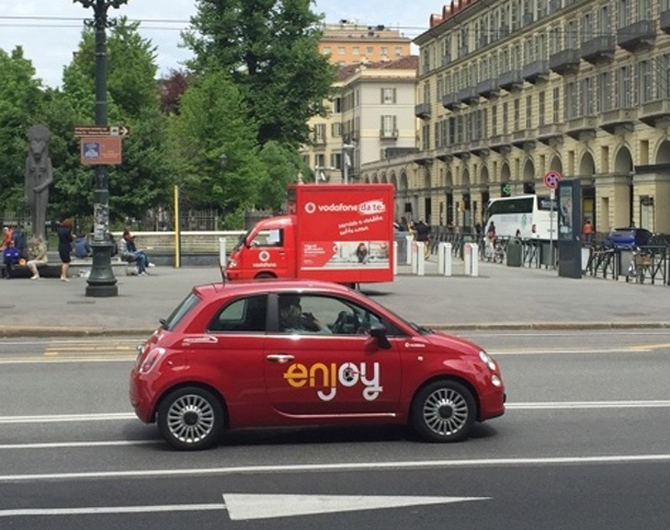 同じくトリノで。イタリアにおいて「CAR2GO」と並ぶカーシェア大手「エンジョイ」。赤い「フィアット500／500L」を使用している。トリノ・ポルタヌォーヴァ駅前で。
