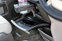 カーブを描きつつせり出す、前席用のセンターテーブル。写真上方に見える格納式のドリンクホルダーも、センターコンソールから斜め助手席側に向かってスライドする。