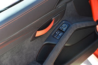 軽量化のためにインナードアハンドルも簡素化。車内側からは、写真のオレンジのストラップを引っ張るとドアが開く仕組みだ。