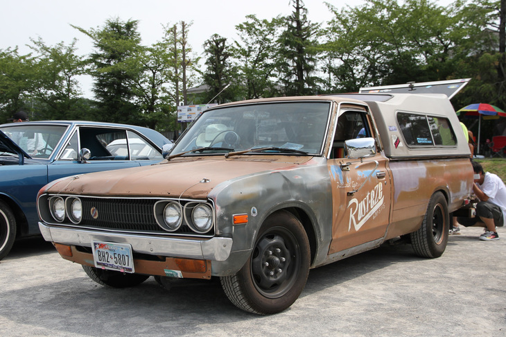 1974年「ダットサン・トラック1500」。ラット（あえて汚れやサビなどを目立たせたカスタム）風に仕上げ、荷台にハードシェルを載せた、アメリカンな雰囲気の型式名620のダットラ。