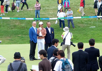 写真撮影に対応する、石川 遼選手（中央）と長嶋茂雄大会名誉会長（左）、セガサミー代表取締役会長兼社長の里見 治氏（右）。
    