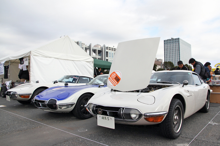 今年誕生50周年を迎える「トヨタ2000GT」のワンメイククラブであるトヨタ2000GTオーナーズクラブ・ジャパンのクラブスタンド。右端の後期型（1969年）は「練馬5」のシングルナンバー付きである。