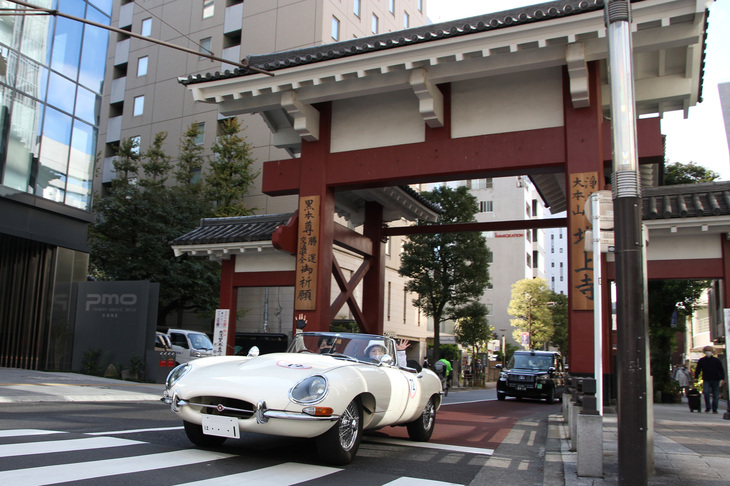 大門をくぐり抜けた、右ハンドルの本国仕様の1965年「ジャガーEタイプS1 4.2ロードスター」。ゴールまであと少し。