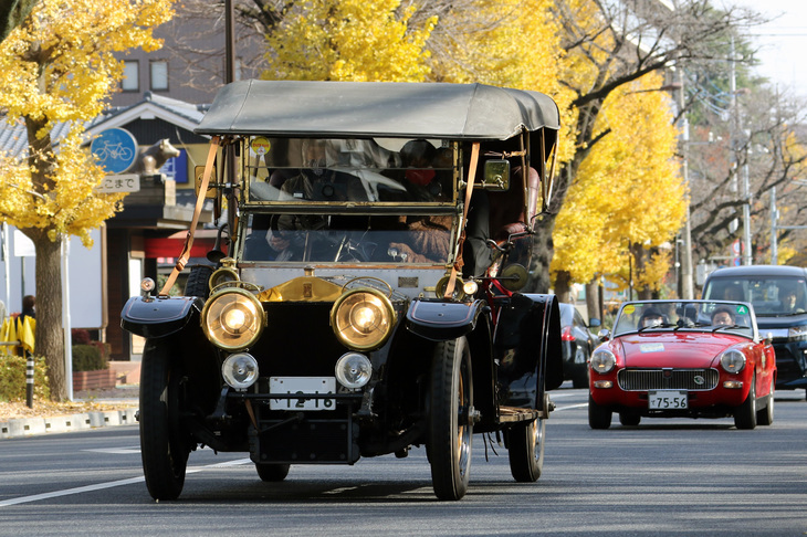 日本ロールス・ロイス＆ベントレー・オーナーズクラブ会長の和田篤泰氏がドライブする1910年「ロールス・ロイス・シルバーゴースト」。日本初のガソリン自動車遠乗会の実施から2年後につくられた車齢110歳のこのクルマで、和田氏はイベントの開催地がどこであろうと、神奈川県のご自宅から自走で参加する。続くのは「MGミジェット」。