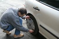 カー用品店の店員さん。写真は、「ランチア・デルタ」のあとボクが乗っていた「フィアット・ブラーヴァ」に、ホイールキャップを装着してくれているところ。