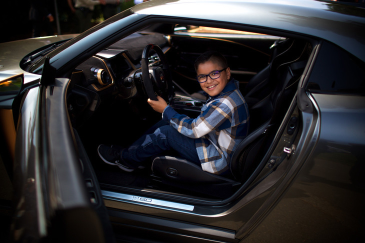 「日産GT-R50 by Italdesign」のドライバーズシートに座り、ご満悦な様子の男の子。内外装のデザインは日産デザインヨーロッパと日産デザインアメリカが担当。イタルデザインは開発、設計、製造を担当している。