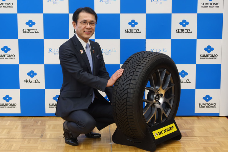 住友ゴム工業の山本 悟 代表取締役社長と、ダンロップのオールシーズンタイヤ「シンクロウェザー」。