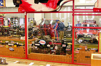 【写真上】現在、メガウェブのヒストリーガレージ2階で開催されている「レビン＆トレノ展」では、D1グランプリ仕様や頭文字D仕様の「AE86」が展示されている。【写真下】レストアは、ヒストリーガレージ1階にある「レストアピット」で実施。2階のヒストリックカーコレクションに展示されている国内外の名車も、すべてここでのレストア作業を経たもの。開館以来、約6年のあいだに10台ほどのクルマたちに命を吹き込んだ。