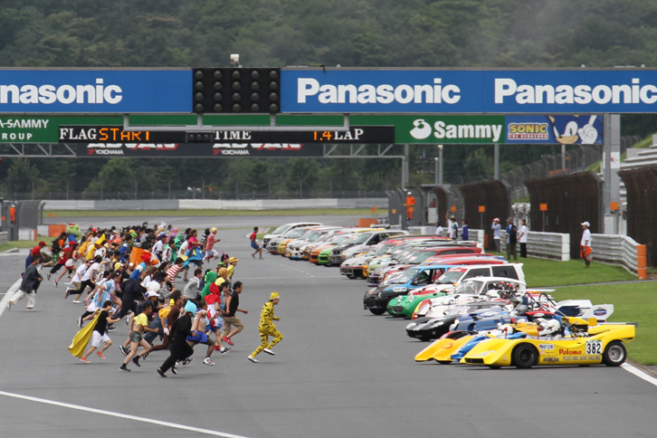 午前8時、仮装したチームスタッフがマシンに駆け寄り、安全確認シールをはがす変則ルマン式スタートで、10時間1000kmの戦いが開幕。スタートまでに雨は上がり、路面は乾き始めている。