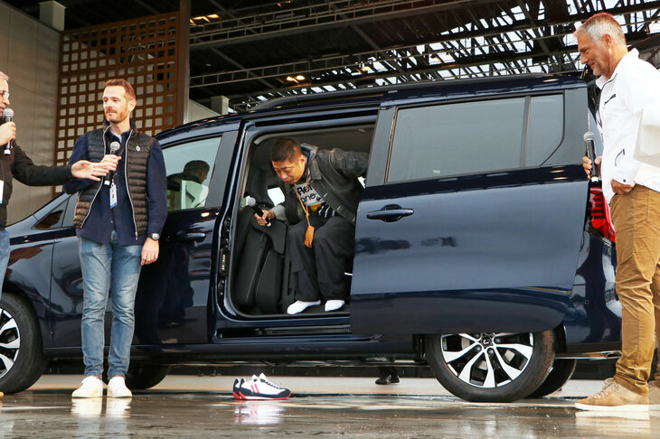 ステージでの車両紹介中に、「クツを脱ぐので、乗車してもいいですか」と切り出した安田さん。早速、現行のモデルにはない3列目シートのアクセス性や空間の広さをチェック。そのゆとりある空間とシートアレンジの多彩さに驚き、「欲しい」を連発していた。その結果、ルノーのハインツ・ユルゲン・レーヴLCV部門上席副社長（写真向かって右）から“購入宣言”を迫られることに……。