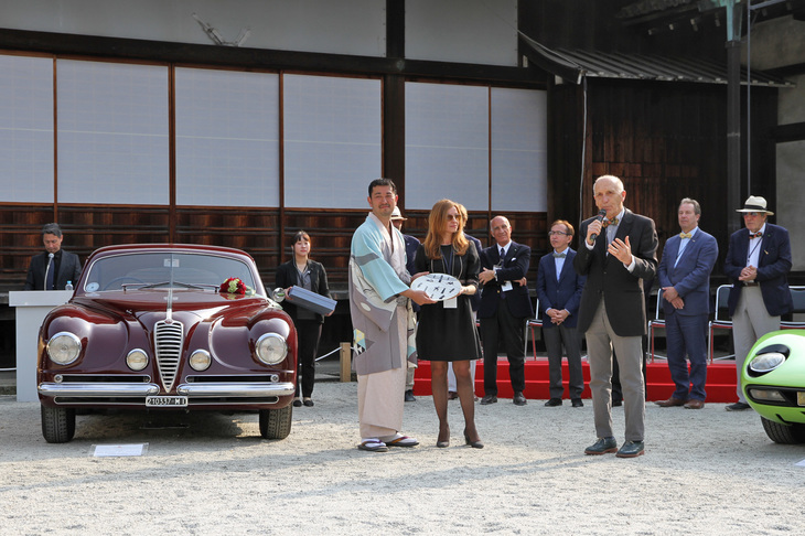 表彰式の最後にサプライズとして、審査委員長であるランボルギーニ博物館 キュレーターのアントニオ・ギーニ氏（前列右）から、総合プロデューサーの木村英智氏（同左）にプレゼントが贈呈された。