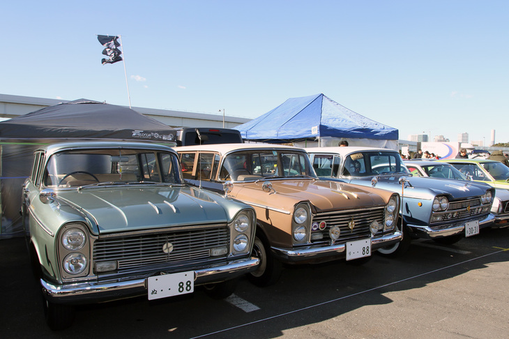 4台の初代「日産セドリック」を展示した「初代セドリック友の会」から、2台の縦目の「バン」と横目の「エステートワゴン」。真ん中のバンは最初期となる1961年式で、加えて特注の寝台車仕様である。