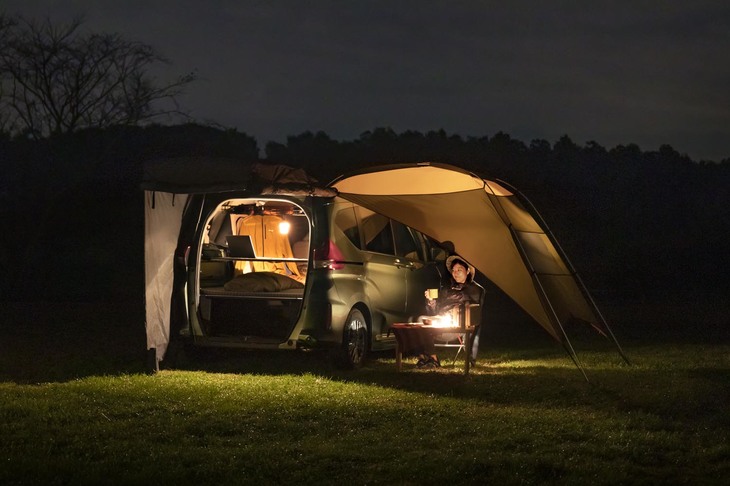 夜のキャンプ場に、明かりをともす車中泊車が浮かび上がる。写真は小川キャンパルのカーサイドタープを取り付けた「フリード＋」。（写真＝ホンダアクセス）